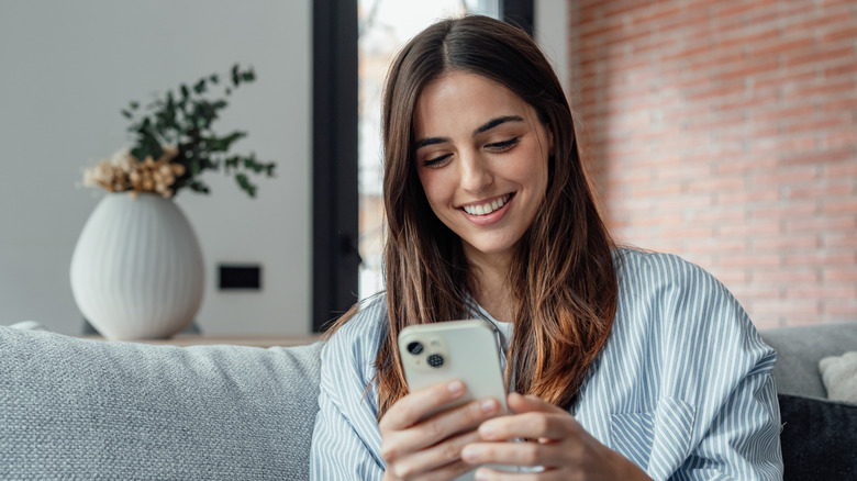 Woman holding smartphone while smiling