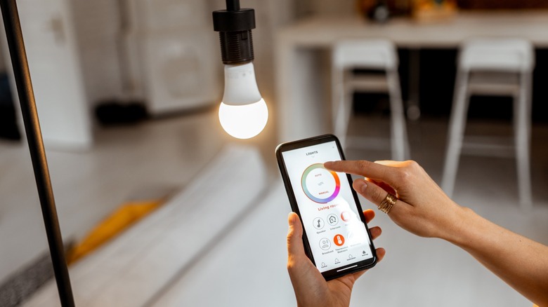 a smart LED bulb with its controlling app shown on a smartphone