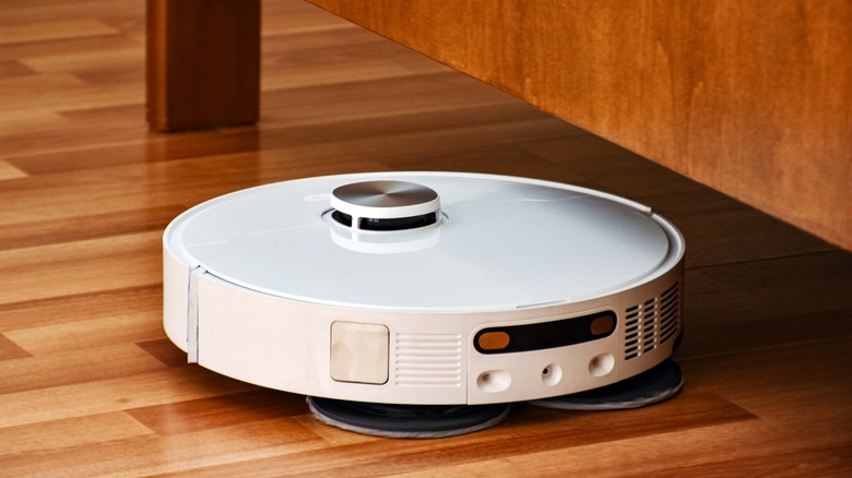a smart robot vacuum heading under a desk to clean under it