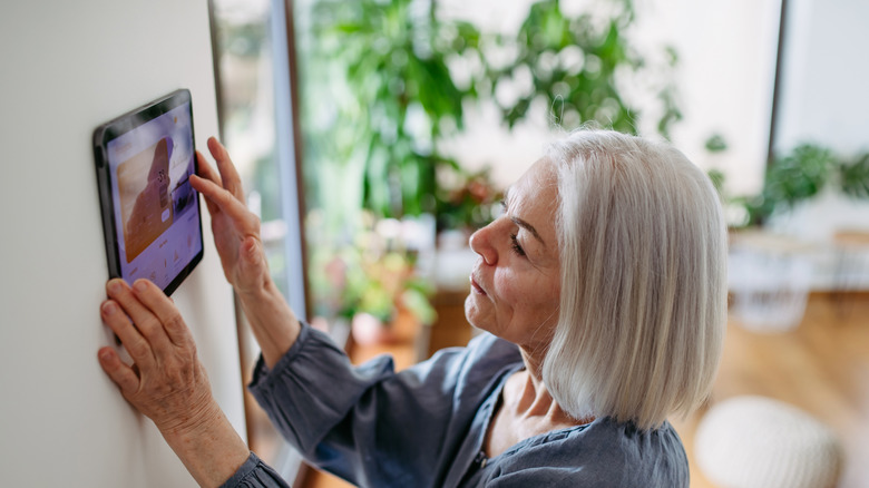 Woman touching a digital display on a wall