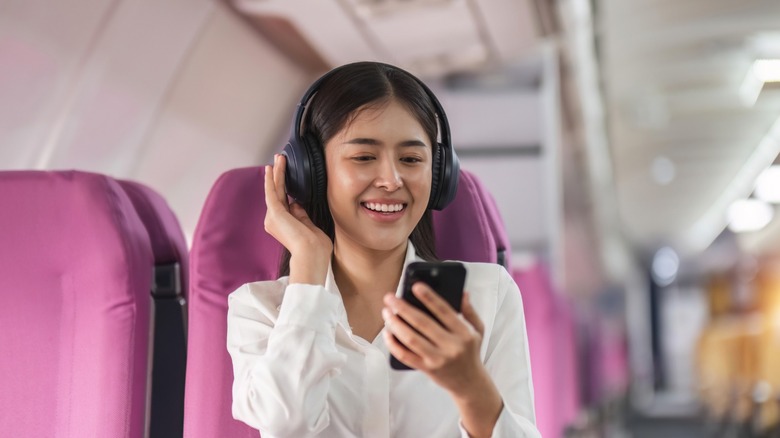 a person watching a video clip on their phone on a plane