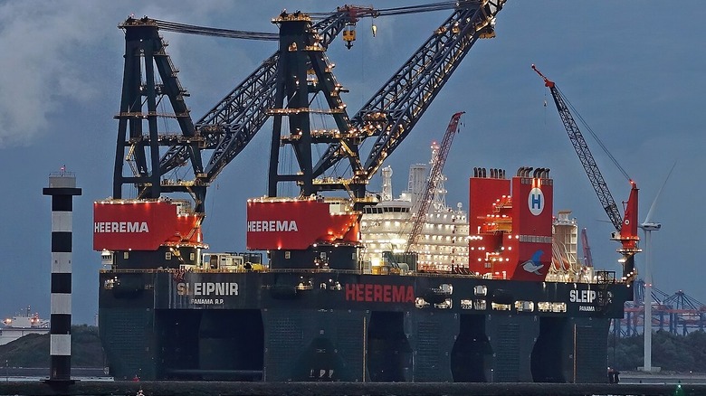 The sleipnir pictured in its home port of Rotterdam, with cloudy skies and hills visible in the background