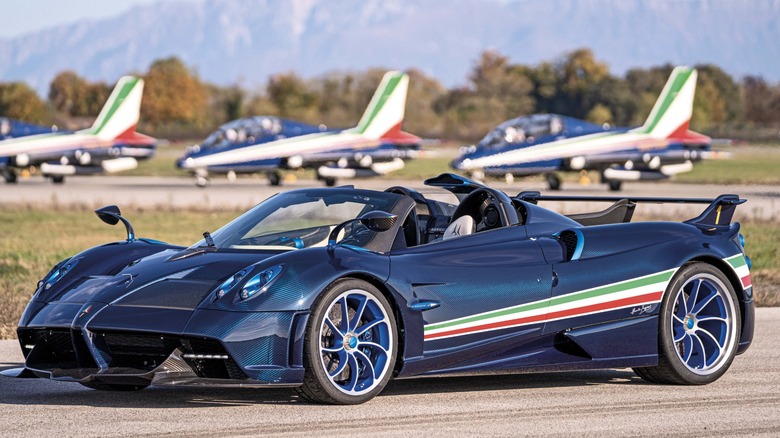 A Pagani Huayra Tricolore parked in front of a row of Aermacchi MB-339A airplanes