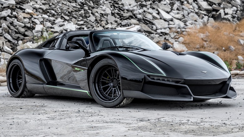 The Rezvani Beast Alpha X Blackbird parked near a rock pile
