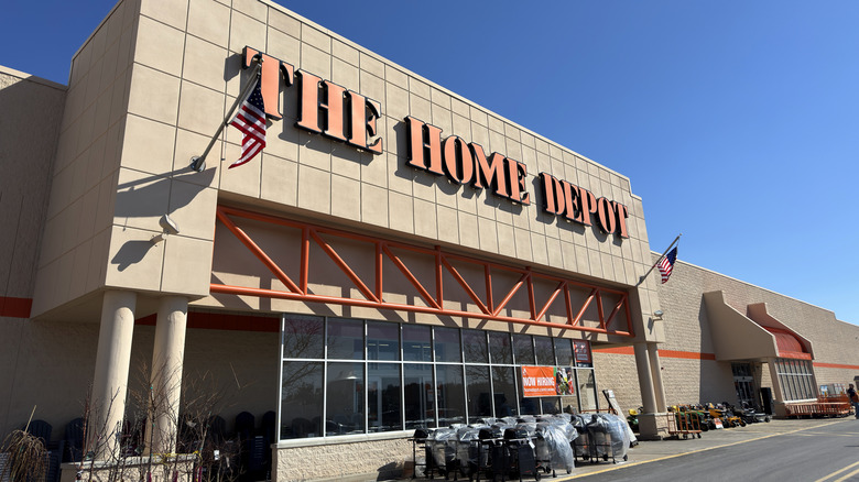 A beige Home Depot warehouse storefront with "The Home Depot" in orange lettering above the entrance door.