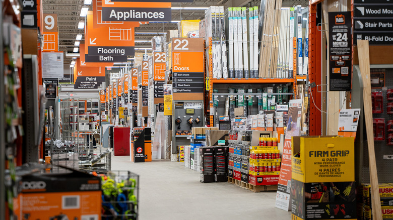 One of the empty main aisles inside a Home Depot location, with items stocked on shelves.