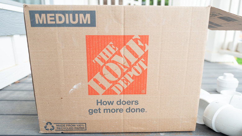 A small, square, brown cardboard carton with the Home Depot logo on the side, placed on a flat surface.