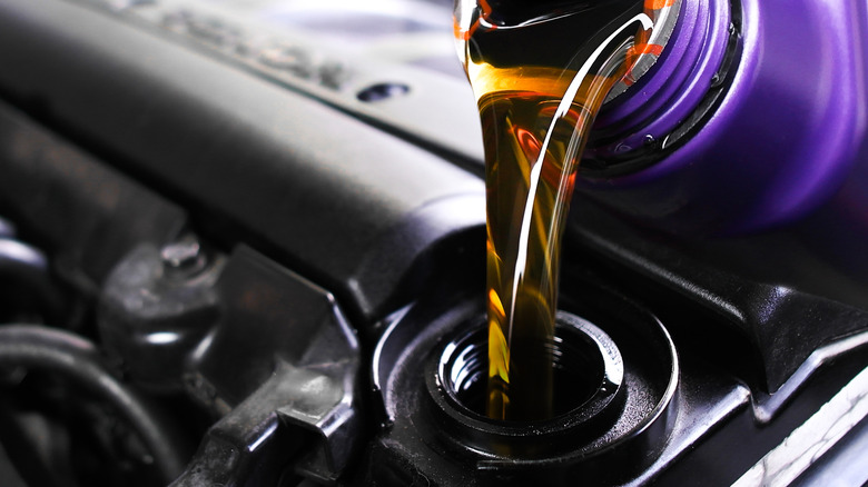 Pouring automotive oil into a car.