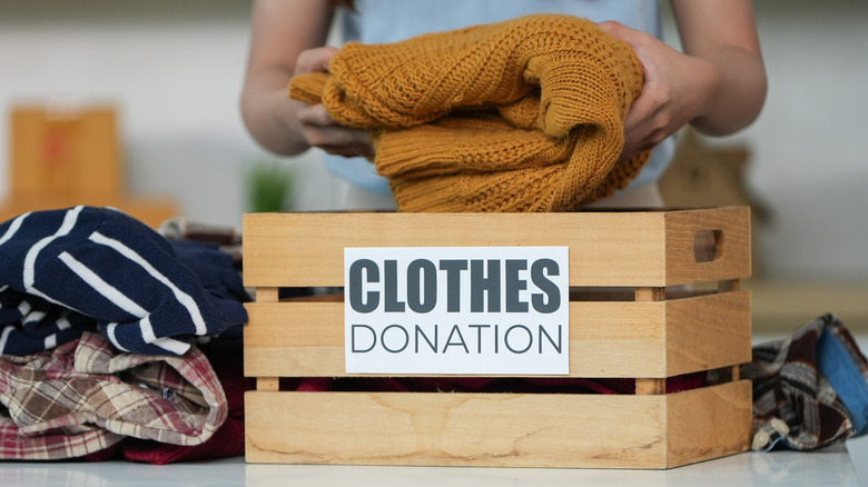 Wooden box with "Clothes Donation" written on it.