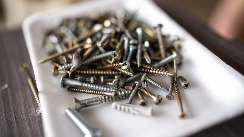 A plastic dish full of loose screws.
