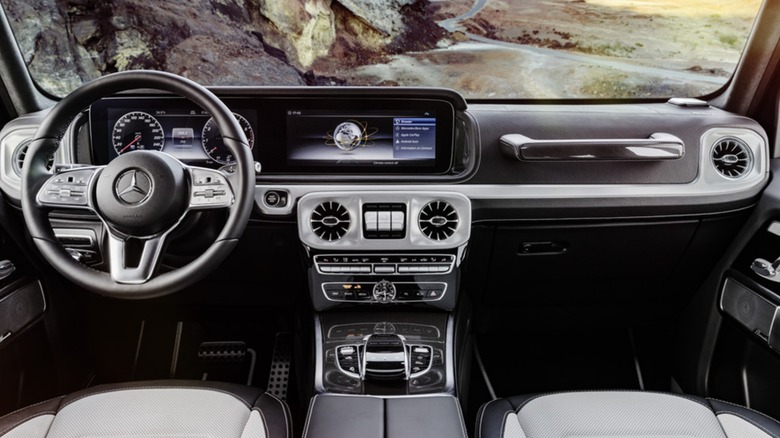 An interior shot of the luxurious 2017 G-Class, showing the dashboard, steering wheel, and center console outfitted in silver and black