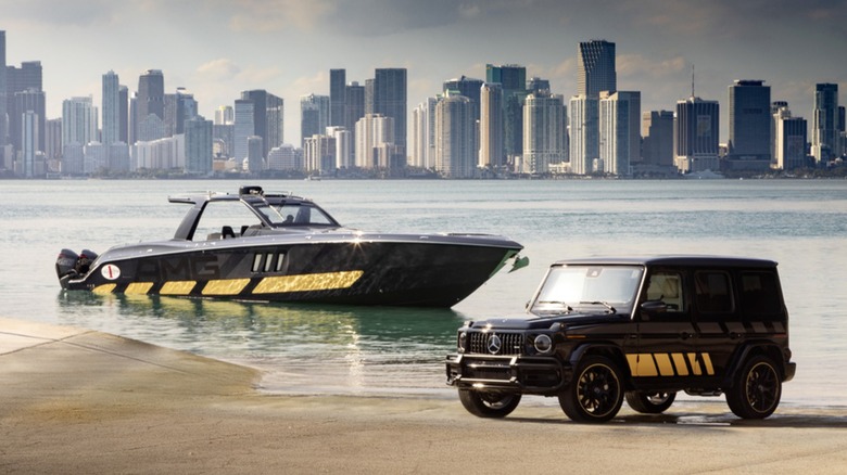 An opulent black and gold Mercedes AMG G63 Cigarette Edition on the beach near a matching 59-foot Tirranna AMG Edition boat