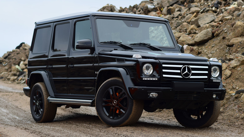 A black G-Class with tinted windows sitting on a dirt road