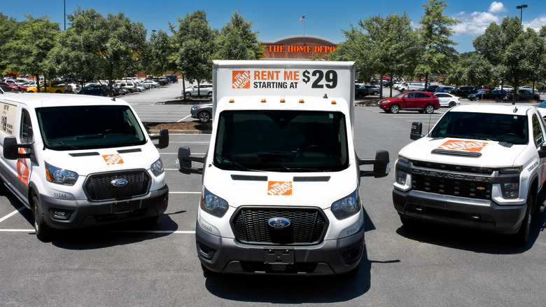 Three of the rentable vehicles from Home Depot in front of a Home Depot store.