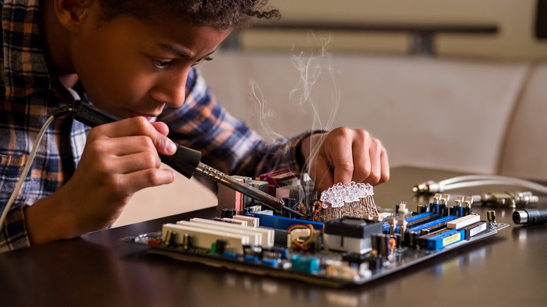 Child soldering motherboard