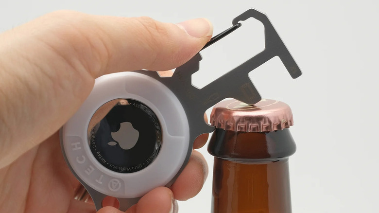 Atech AirTag Multitool 7-in-1 Pro opening a bottle cap