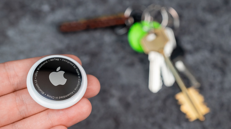 AirTag in hands with keys in the background