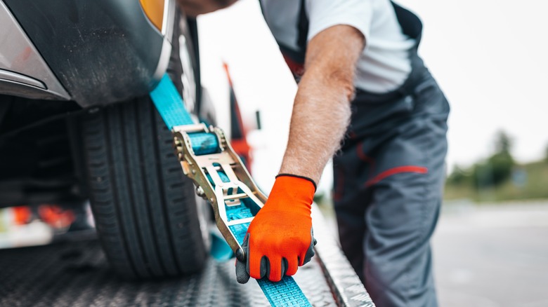 Car being strapped to a tow truck