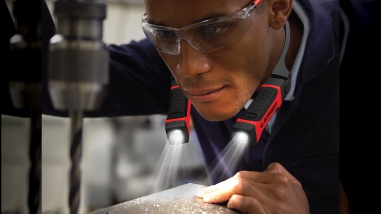 A person using the EZRED Anywhere TM Neck Light while working at a drill press.