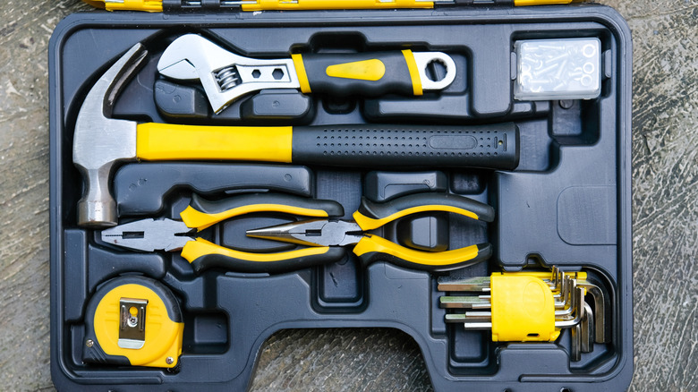 A small set of yellow tools in a form-fitting case, open