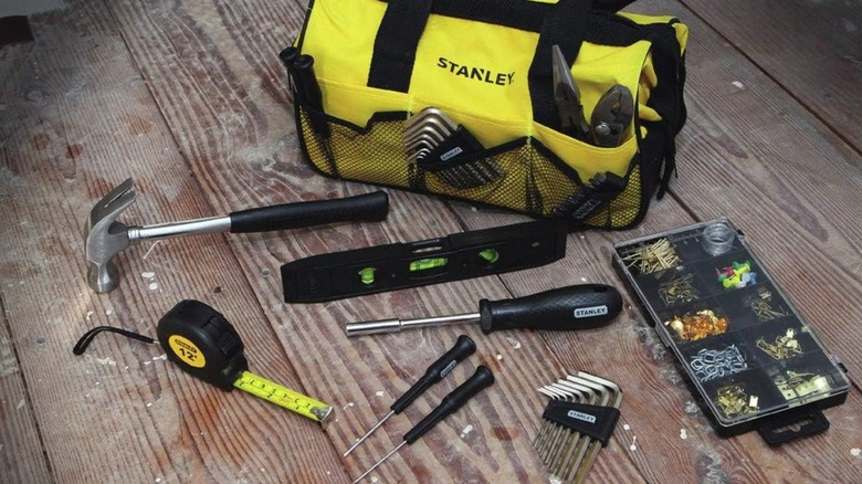 A soft bag with Stanley branding and some of its contents on a wooden floor.