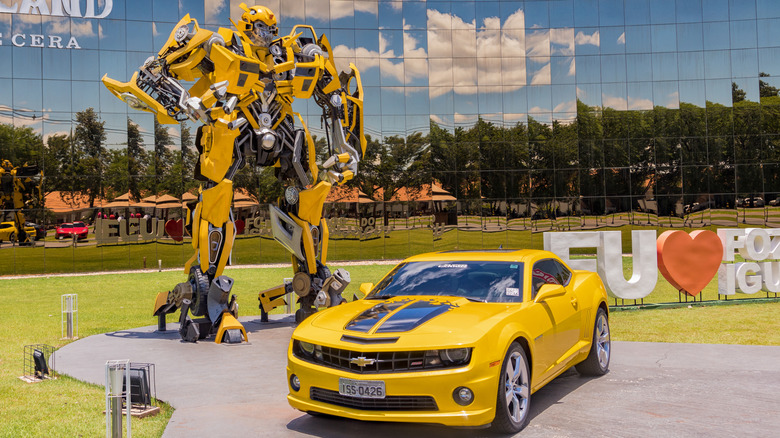 Famous transformer Bumblebee in front of a museum in Brazil, both in robot form as well as with a Camaro parked beside him