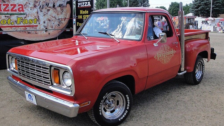 Dodge Lil' Red Express parked by a pizza truck. Note the red color and vertical exhaust stack