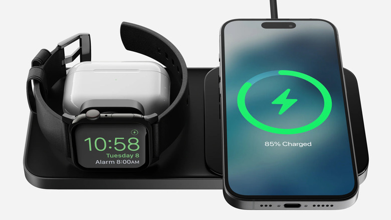Nomad Base One Max with iPhone, AirPods, and Apple Watch on white background.
