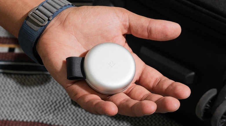 Hand holding a compacted Twelve South ButterFly 2-in-1 MagSafe charger.