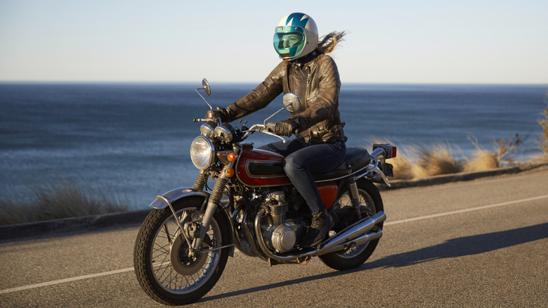 A man riding a touring motorcycle right side view at speed.