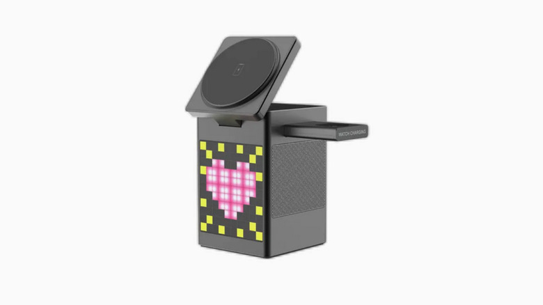 A Bluetooth speaker with wireless phone and smart watch chargers displays a pink heart on its screen.