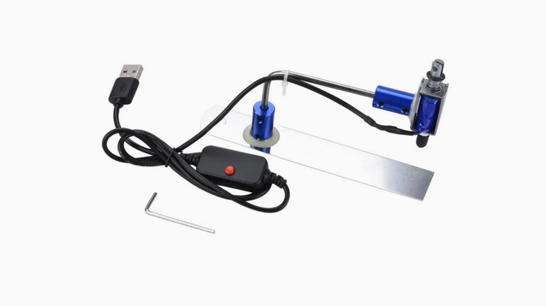 A small USB-powered keyboard clicker, made out of an arched piece of metal placed on top of a straight strip of metal.