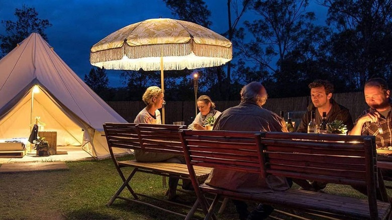 People sitting on wooden benches while camping