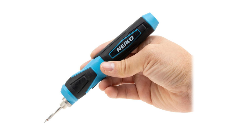 The Neiko soldering ironon a white background, held by a hand.