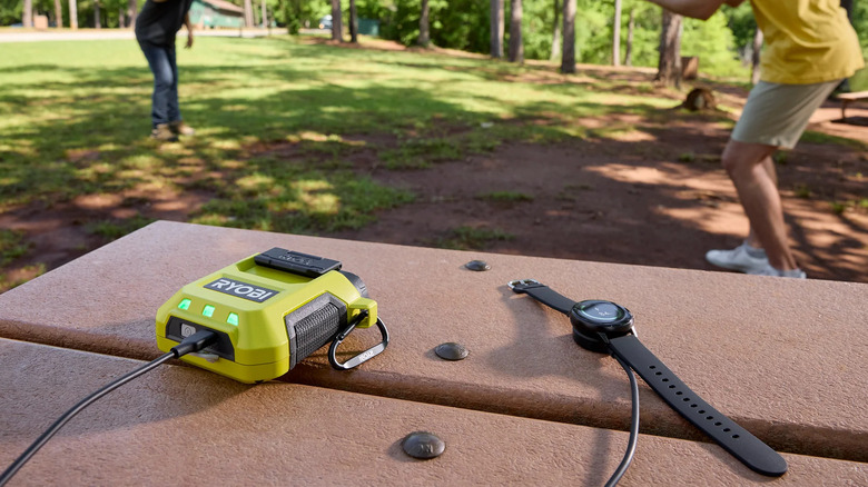 Ryobi USB Lithium 3-port power source on table outdoor.