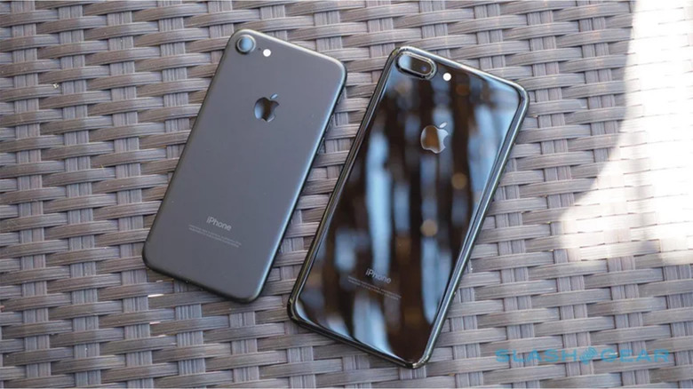 Two iPhones sitting on a wicker table