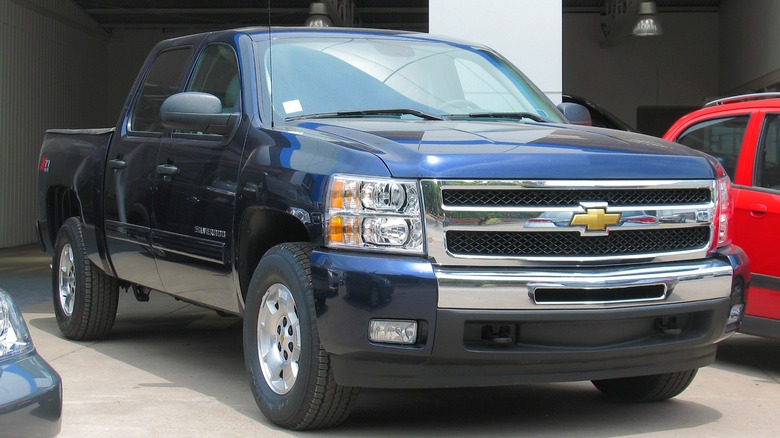 Dark blue 2011 Chevrolet Silverado 1500 parked alongside other vehicles