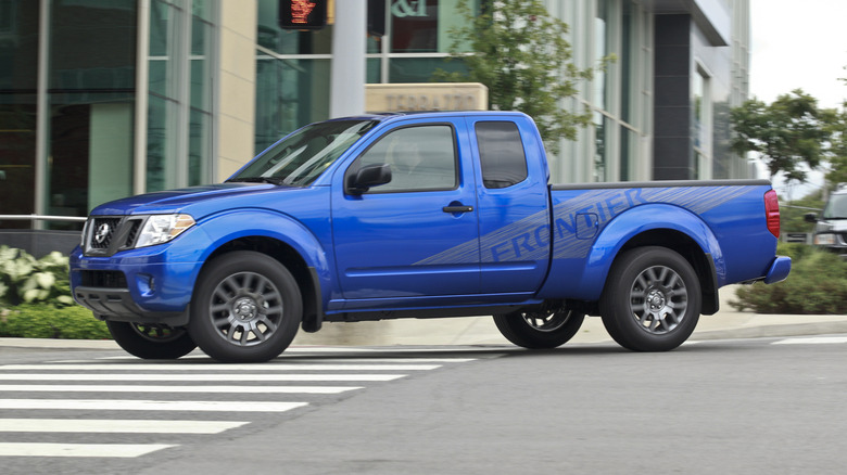 Blue 2012 Nissan Frontier King Cab driving in the city