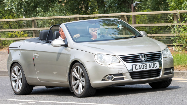 A man driving a Beige 2008 Volkswagen Eos