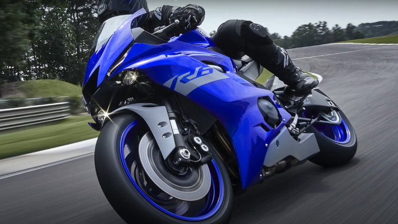 motorcyclist on racetrack riding a blue 2001 Yamaha YZFR6 motorcycle