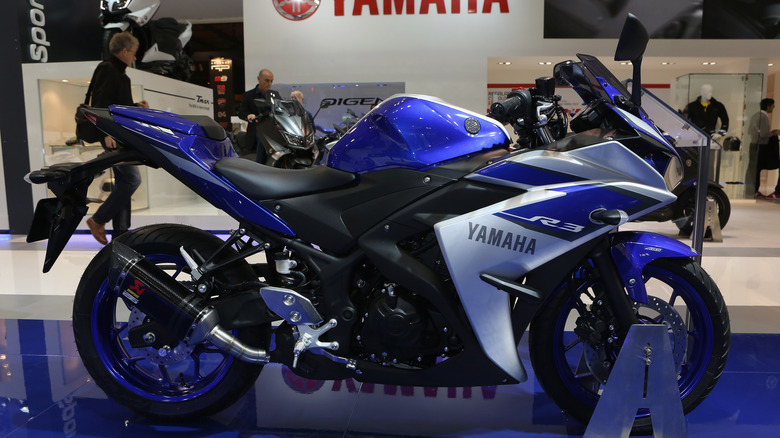 blue and black 2015 Yamaha YZF-R3 motorcycle on display at a showroom