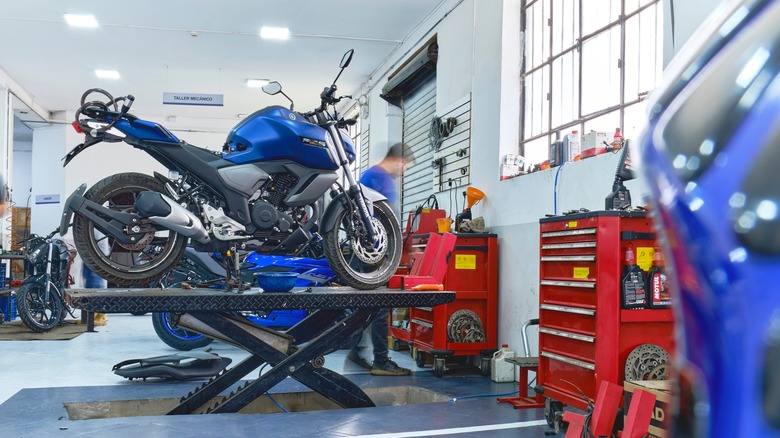 blue Yamaha motorcycle on a lift in a repair shop