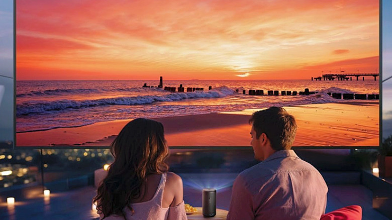 A couple watching a movie outdoors using the Anker NEBULA Capsule 3.