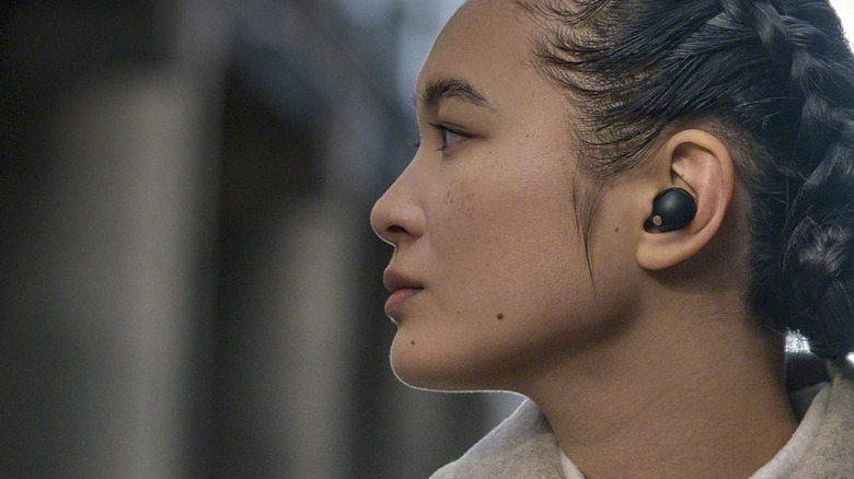 A woman wearing the Sony WF-1000XM5 earbuds.
