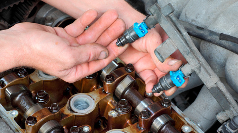A person affixing a fuel injector into the rail