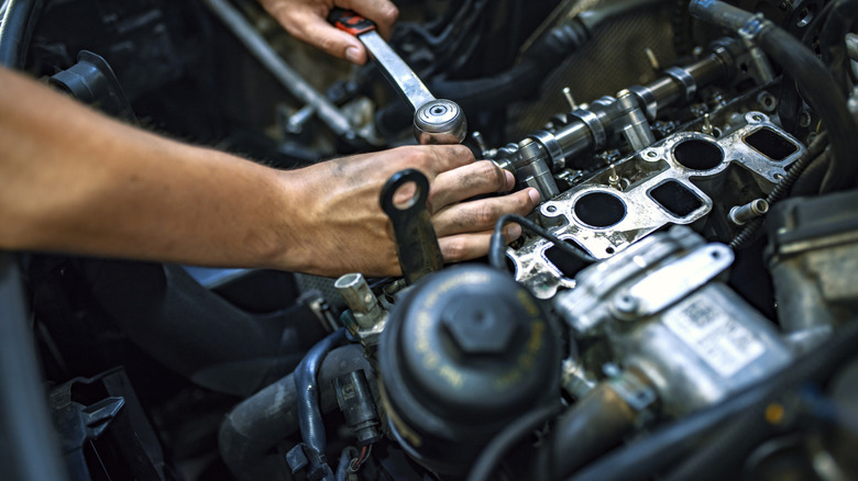 A person working on a a car engine