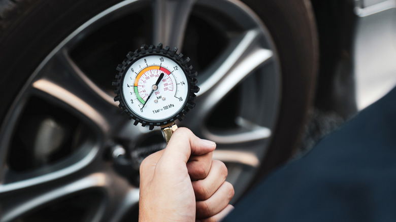 Mechanic with tire pressure gauge