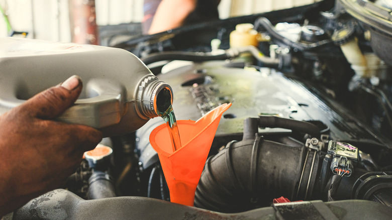 Mechanic pouring transmission oil