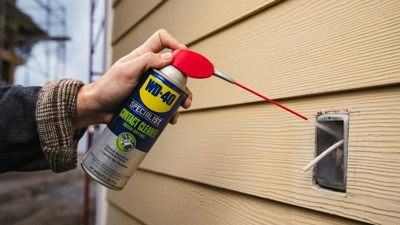 A person using WD-40 Specialist Contact Cleaner on a switch board