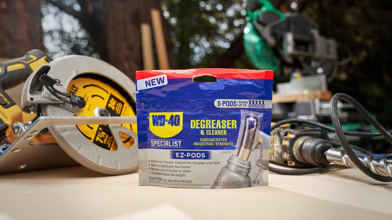 A packet of WD-40 Specialist Degreaser and Cleaner EZ-Pods in front a several tools